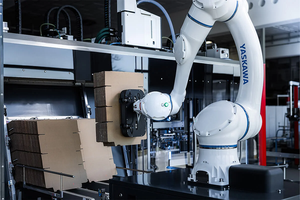 SOMIC CoboLoad - A cobot loads cardboard blanks into the cardboard magazine of a SOMIC 434 packaging machine